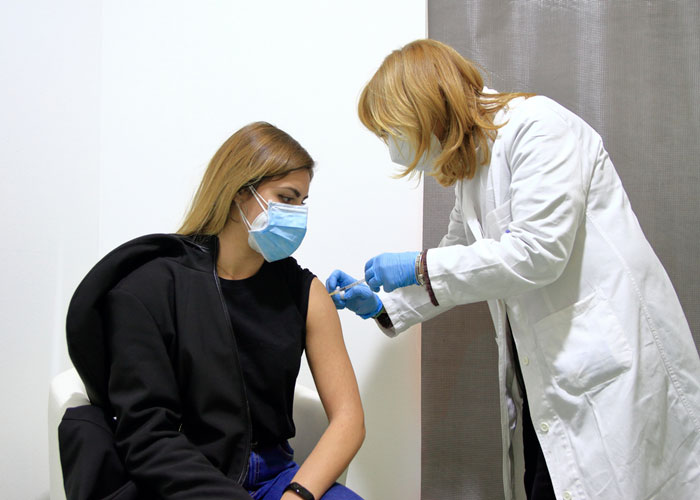 immagine di una dottoressa che vaccina una ragazza